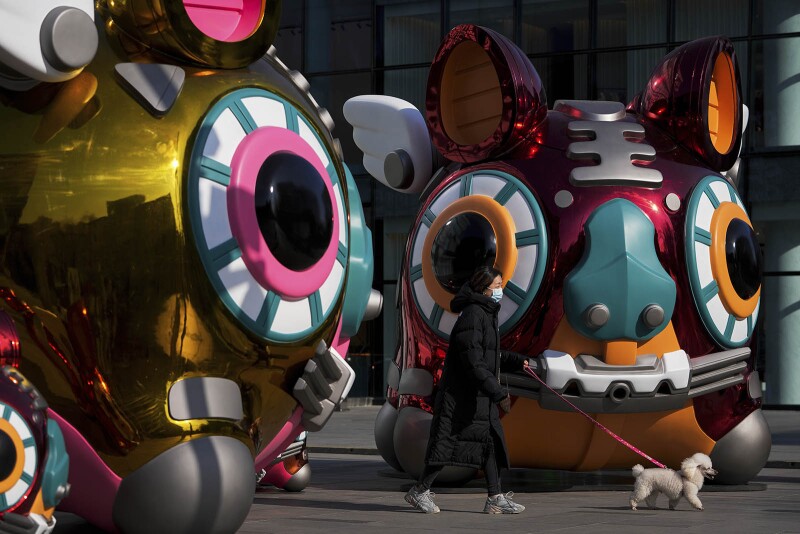 A woman passes robotic-themed tigers during the Lunar New Year Eve in Beijing.