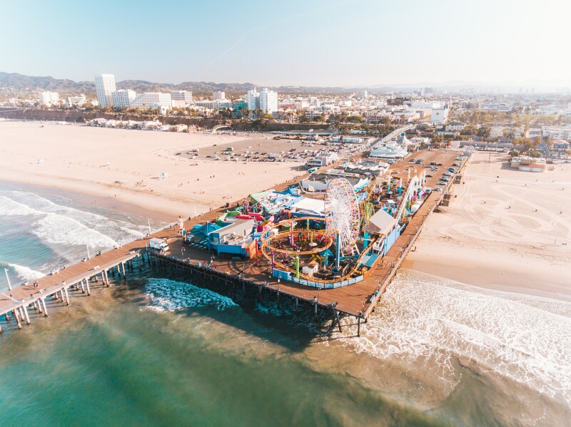 An aerial shot of the Santa Monica pier with city in distance