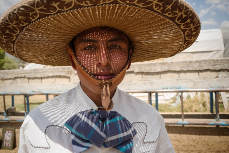 A young man's hat casts a shadow at the Lienzo Charro of Tlalixtac de Cabrera, Oaxaca.