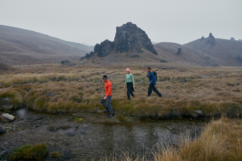 Hikers  walking through terrain wearing items from icebreaker’s Oasis 200 collection.