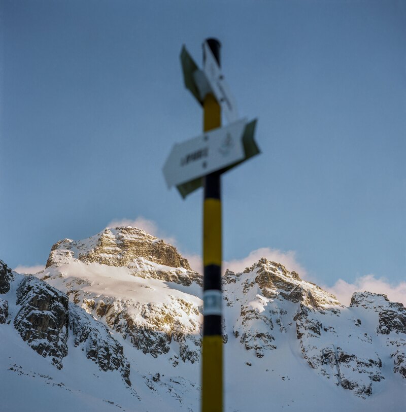A trail sign is centered and blurred in front of the Orlovets peak (2686m) in the Rila mountain range in southwestern Bulgaria