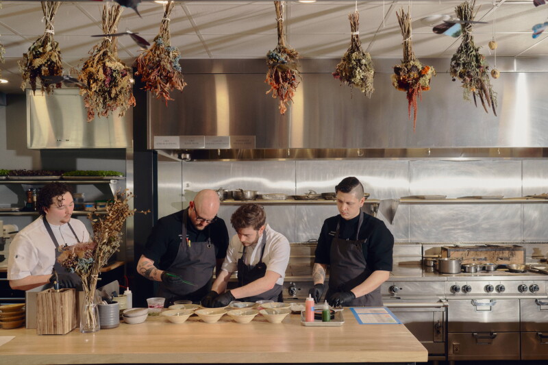 A team of chefs prepares dishes at Counter-.