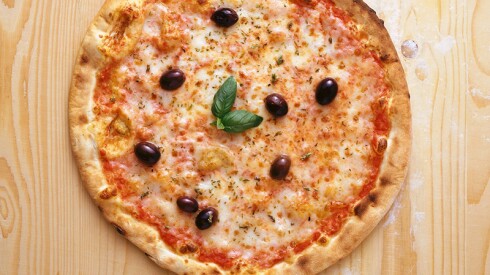 Pizza with black olives, basil and oregano