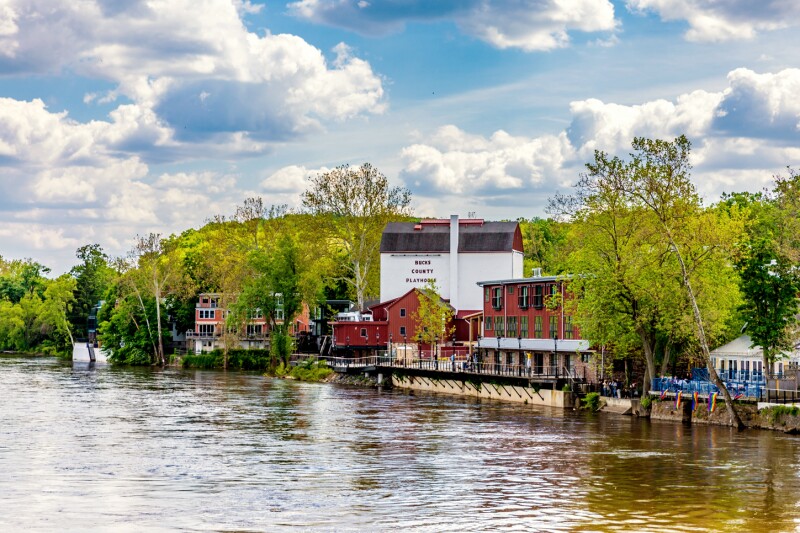 Red and white buildings on a riverfront with trees
