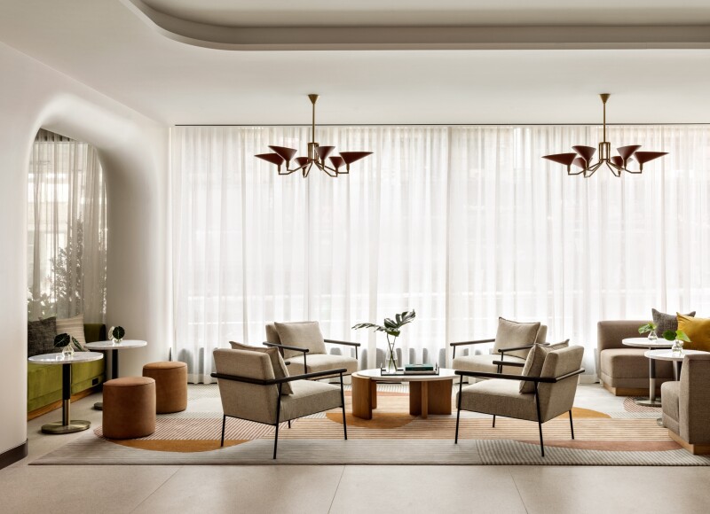 The lobby of New York's Hotel Theta which features mid-century-inspired furnishings, curved walls, and art books