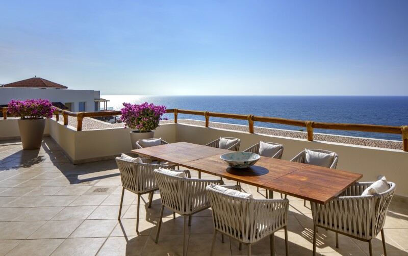 A Family Residence Suite's large balcony with a dining table and eight chairs facing ocean at Grand Velas Riviera Nayarit