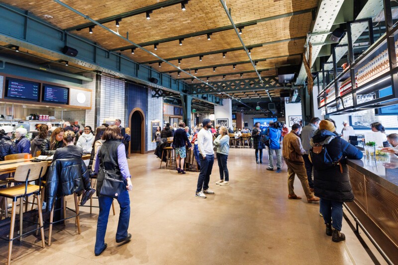 Interior of Track 15, with people standing at food counters that line each side