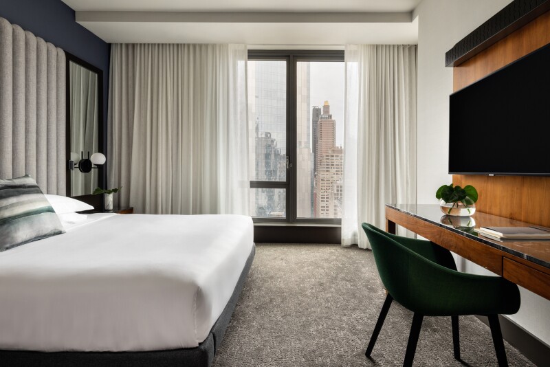A king-size bed in a hotel room with NYC views