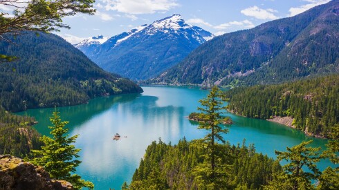 turquoise water of Diablo lake surrounded by pine tree covered mountains in North Cascades National Park, Washington, USA