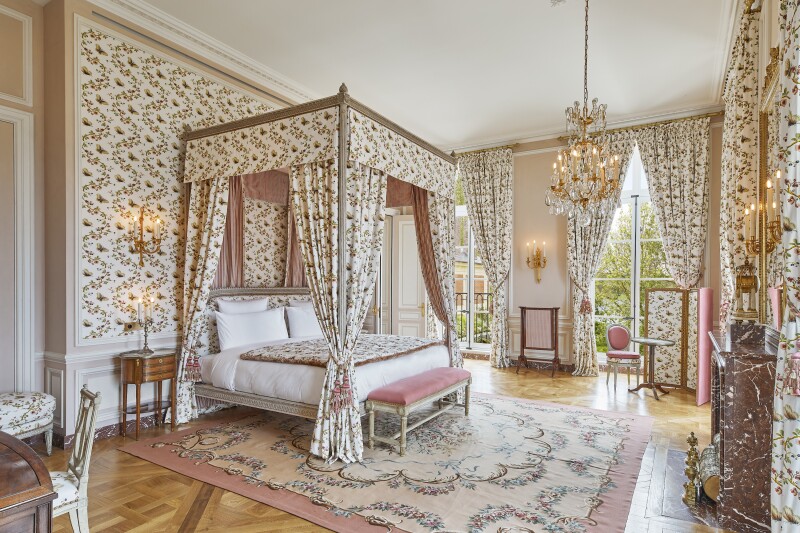 Four-poster bed in the Suite Necker with period-authentic patterned curtains and wallpaper