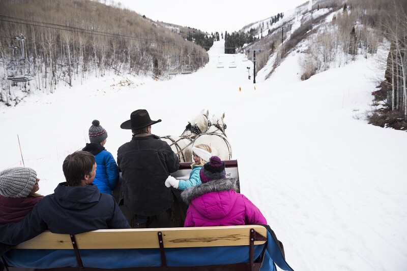 A view of from the back of people taking a horse-drawn sleigh ride in Park City, Utah.