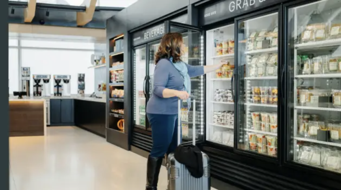 A woman grabs some fruit from a cooler in the United Club Fly lounge in Denver.