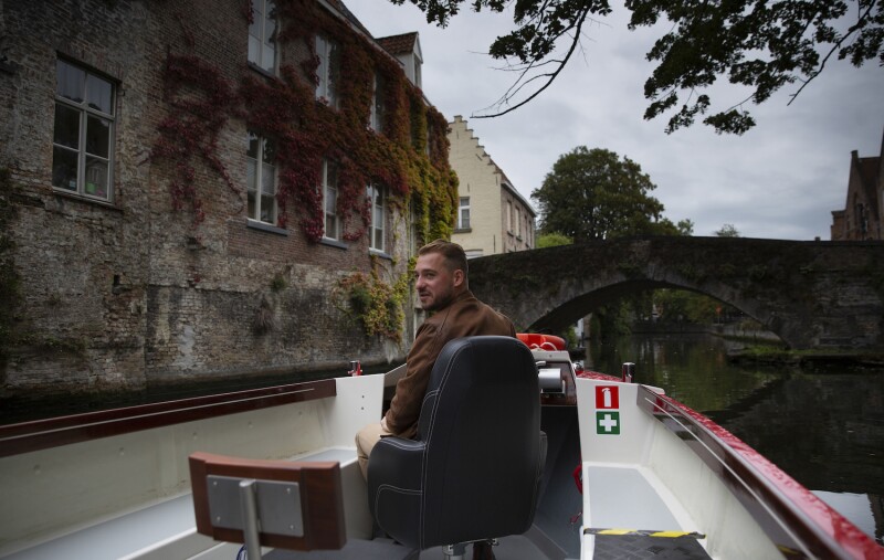 Fourth-generation tour boat operator Michiel Michielsens drives his electric boat down a canal in Bruges.