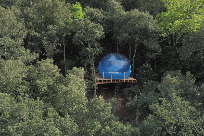 Blue bubble tent on raised platform in a forest in France
