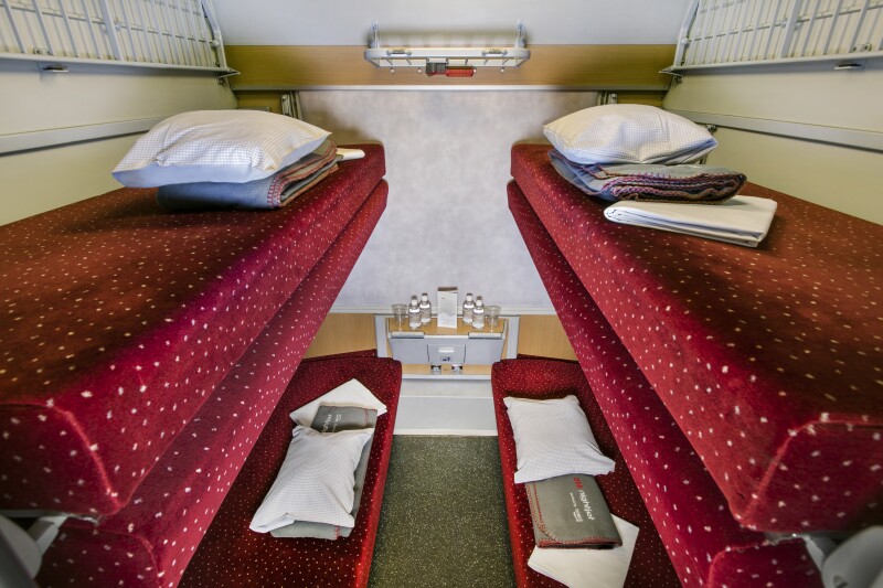 The stacked beds inside Nightjet's "mini cabin," with pillows, folded sheeting, and red, white polka-dotted bed covers