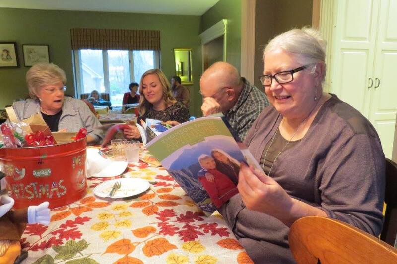 Chez Chesak’s family looks through travel brochures during a holiday meal.
