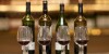 Red wine glasses and wine bottles on a counter of a wine cellar