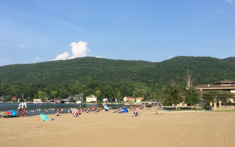 The sandy swath at Lake George Beach with green hills in background