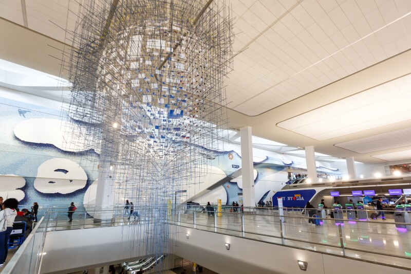 Striking hanging modern art installation in central lobby area of LaGuardia Airport with check-in counters in the background