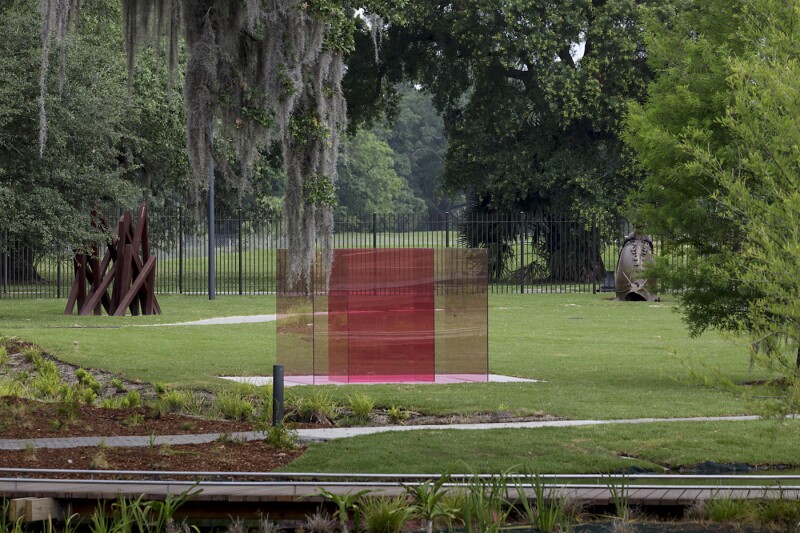 Larry Bell’s sculpture "Pacific Red VI" sits in a distinctly New Orleans setting of live oak trees and Spanish moss.