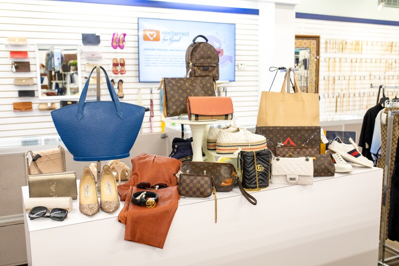 Designer handbags, shoes, and sneakers on a display stand, for sale at the Unclaimed Baggage store in Alabama