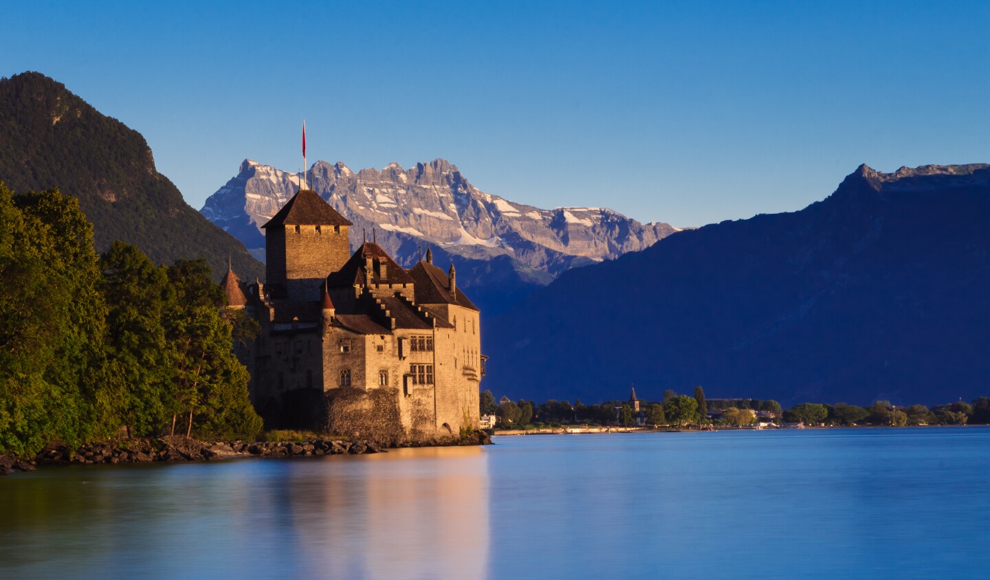 Swiss Château de Chillon on shore of Lake Geneva with dramatic mountains in the background