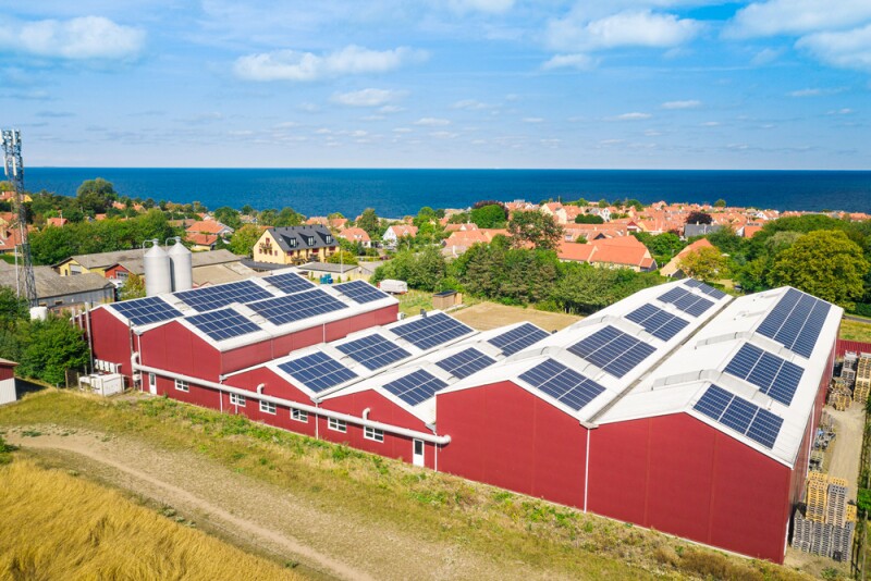Blue solar panels atop red and white Svaneke Brygery