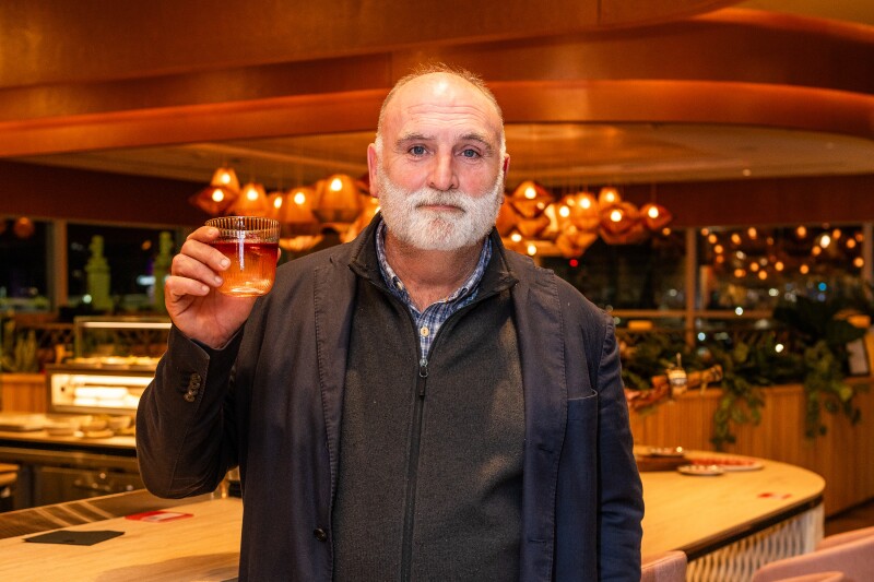 Chef José Andrés raising a glass while standing in the Capital One Landing at DCA