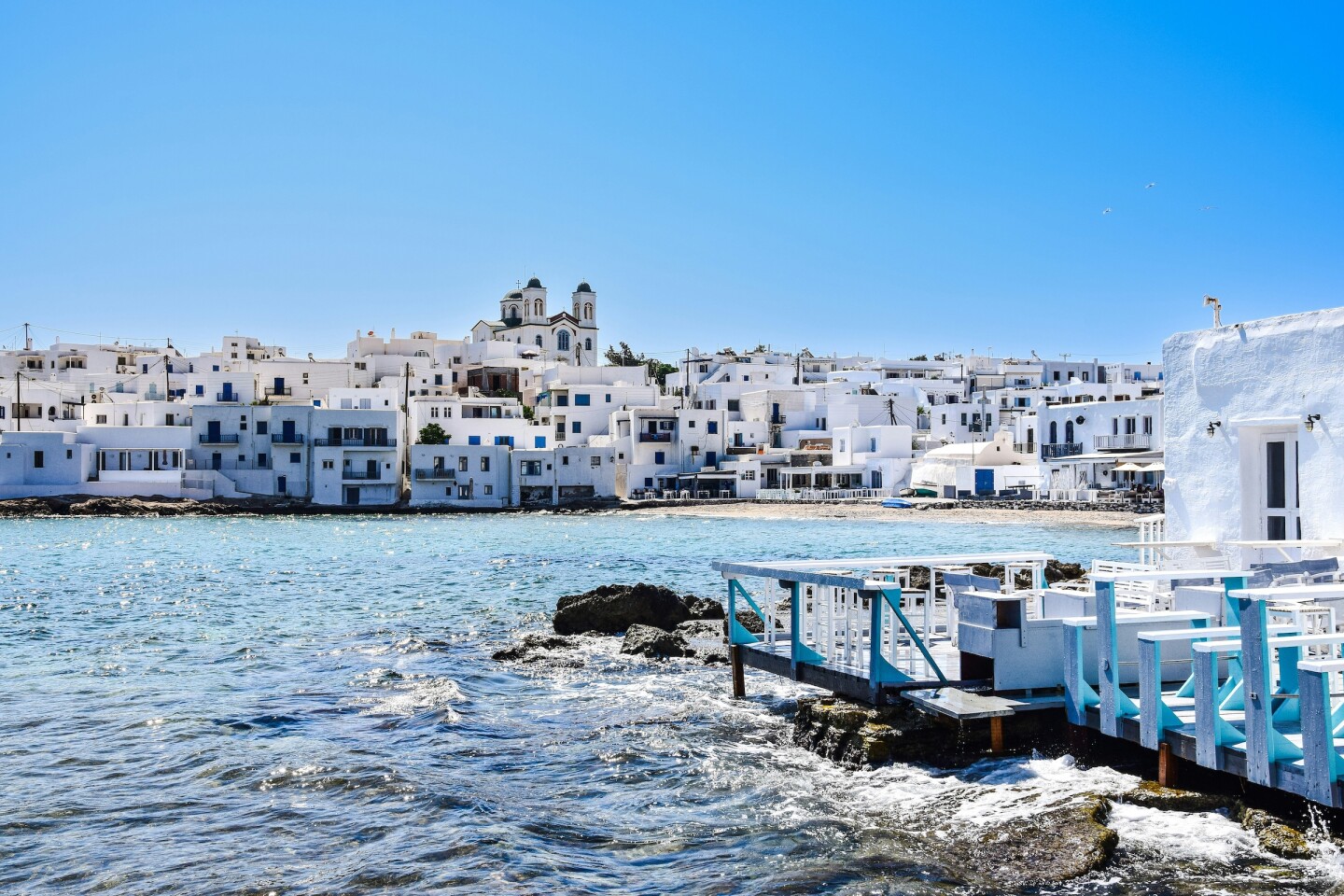 A whitewashed village with a church in the center with water in the foreground