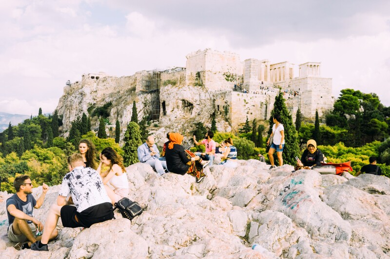 People relax on a rocky landscape in Greece