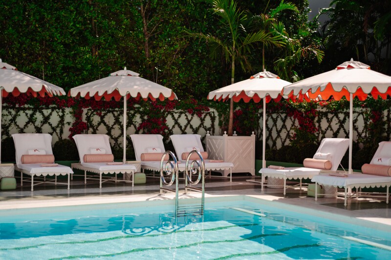 Vineta Hotel pool with white lounge chairs and umbrellas