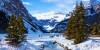 People walking on a frozen Lake Louise in Banff National Park with snow all around