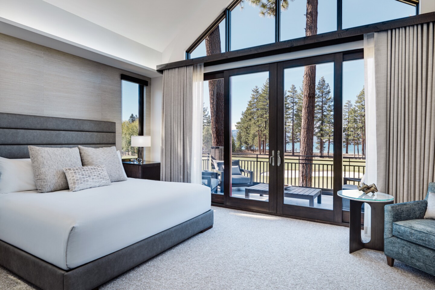 Interior of an Edgewood Tahoe Resort guest room with high ceiling and large windows