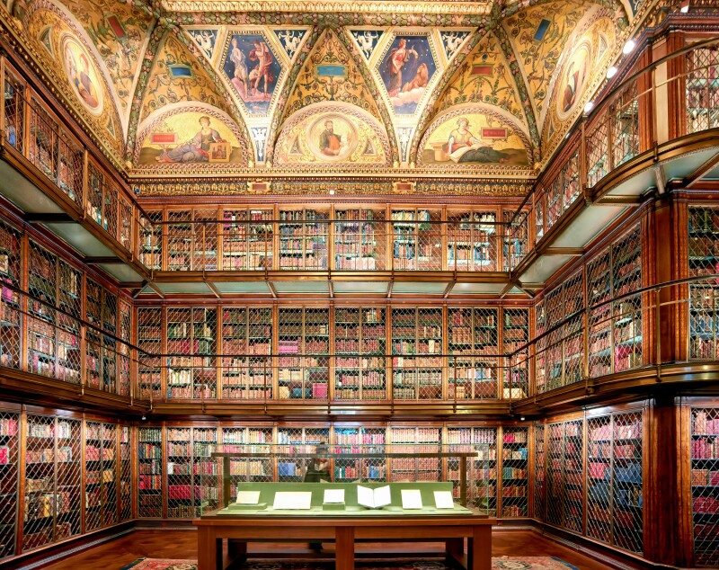 An antique-style library with three floors of books toped by decoratively painted walls at the Morgan Museum