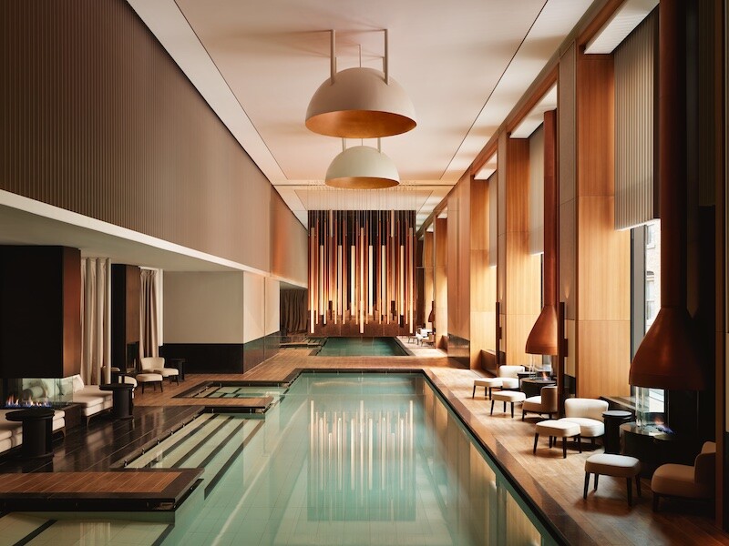 The 65-foot indoor swimming pool at the Aman New York, with daybeds and fireplaces