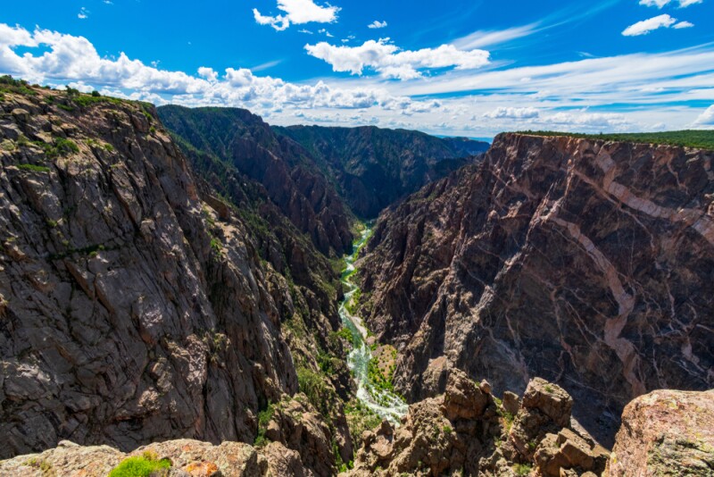 Two steep, dark brown cliffs with a river cutting between them