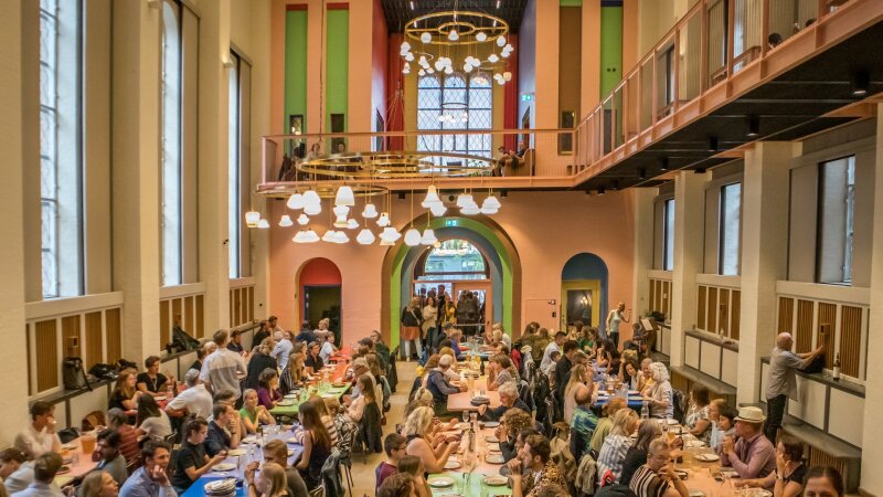 A wide view of Absalon in central Copenhagen, Denmark, filled with diners eating family-style.