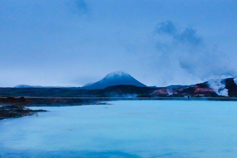 Milky blue water of large lagoon, with mountain in background