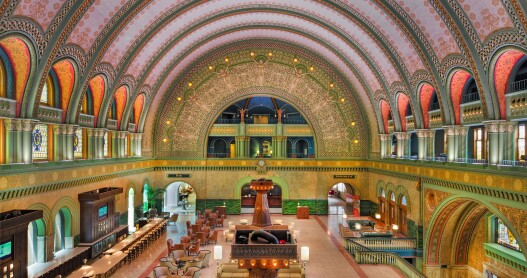 The grand hall of St. Louis Union Station Hotel, Curio Collection by Hilton, has curved ceilings and is decorated with a green-dominant color scheme.