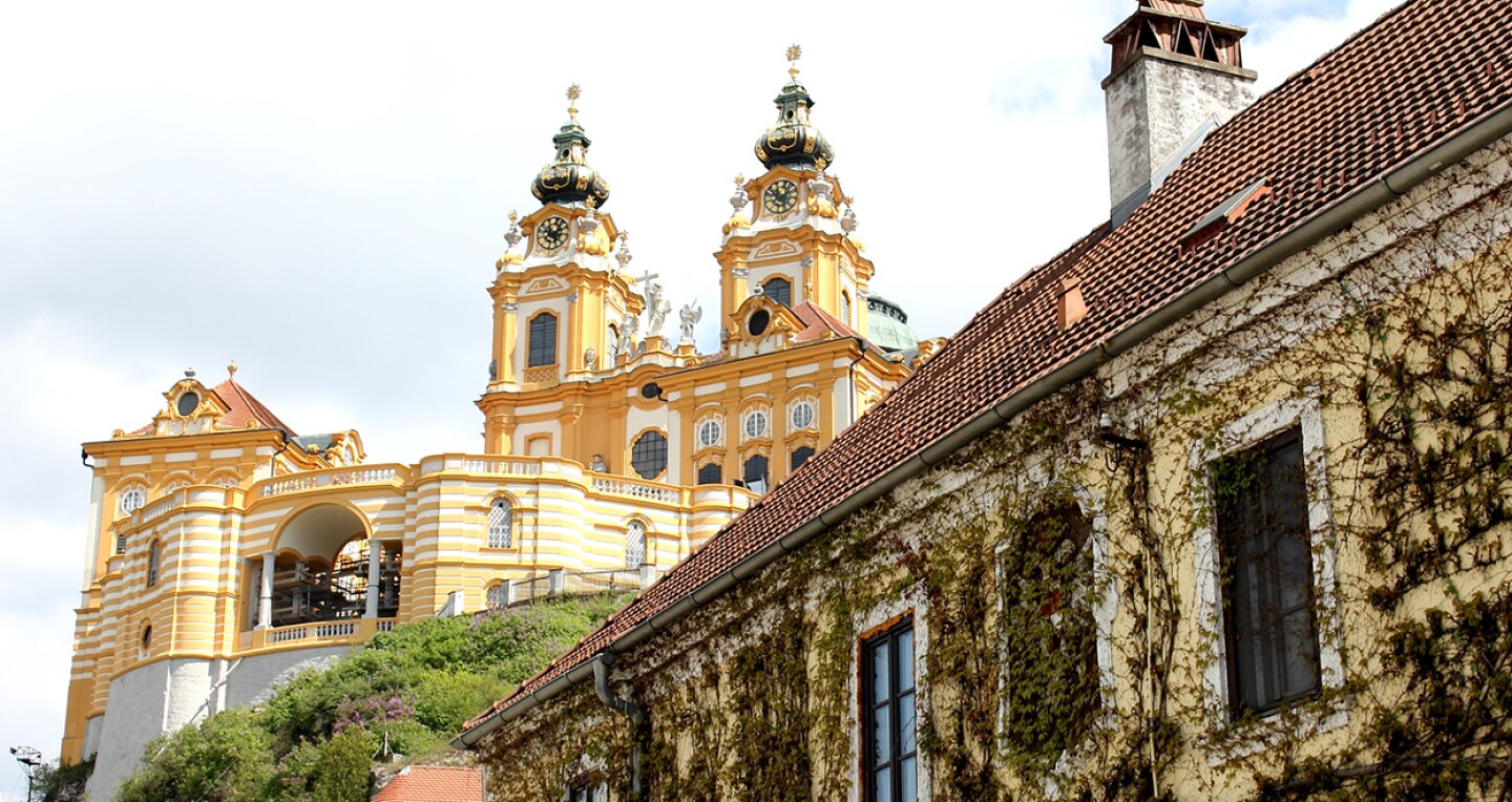 A yellow abbey on a hill.