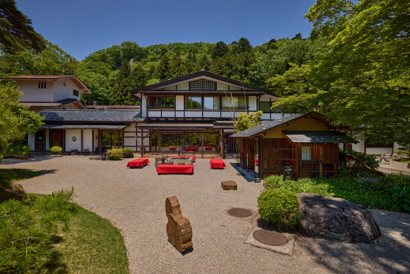 Overhead view of hotel surrounded by trees, with rock garden in foreground