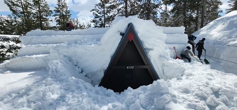 snow piled high on a Lake Tahoe A-frame cabin