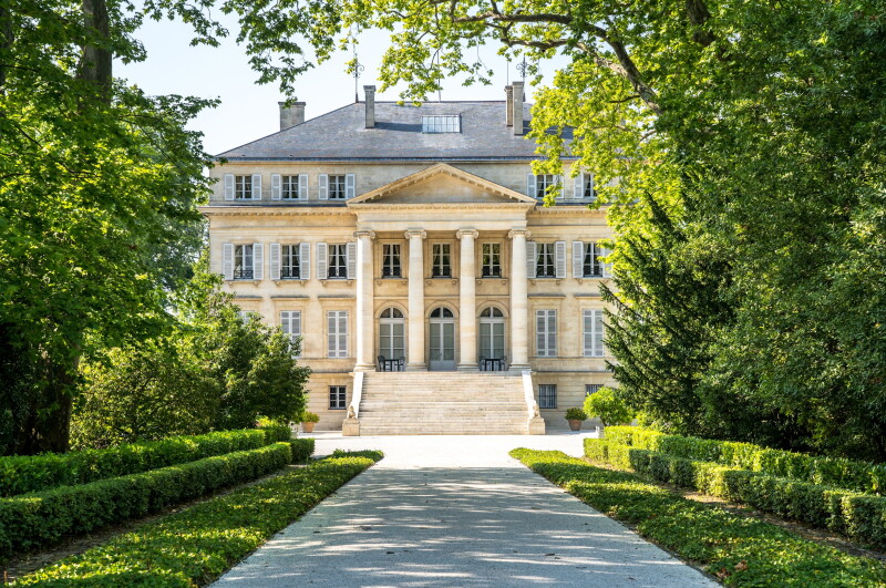Exterior of historic Château Margaux , with portico of four columns viewed from central walkway and garden