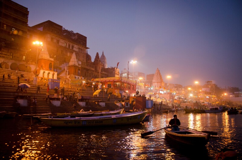 The Ganges in Varanasi at sunset, Uttar Pradesh, seen from water with a few small boats on it