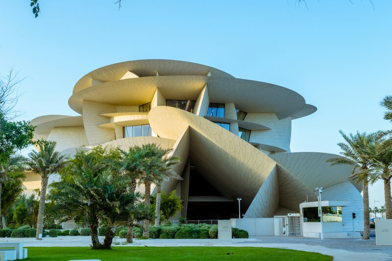 Exterior of the National Museum of Qatar featuring interesting architectural elements such as levels of flat planes going in numerous directions, all intended to look like a desert rose crystal