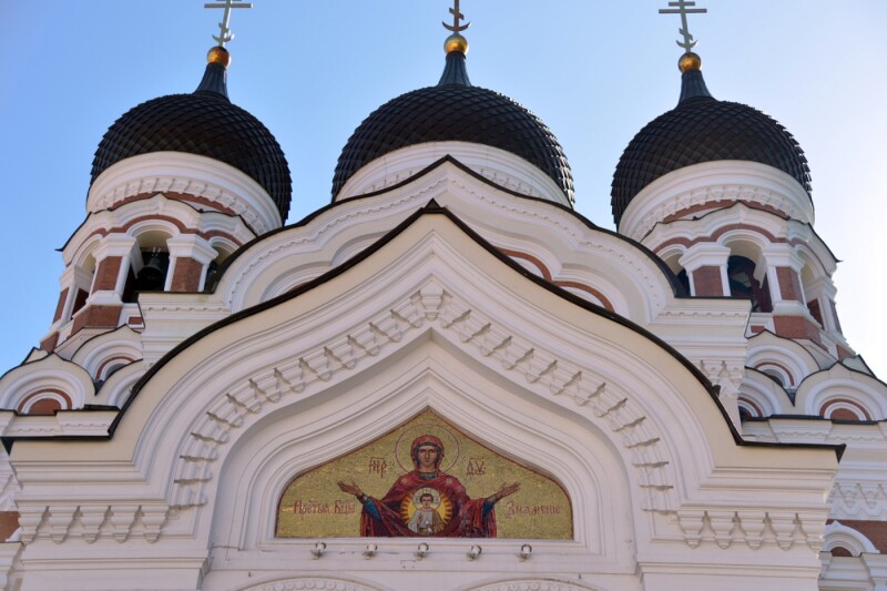 The tall, rounded white spires and a portrait of Jesus on the Alexander Nevsky Cathedral in Estonia.