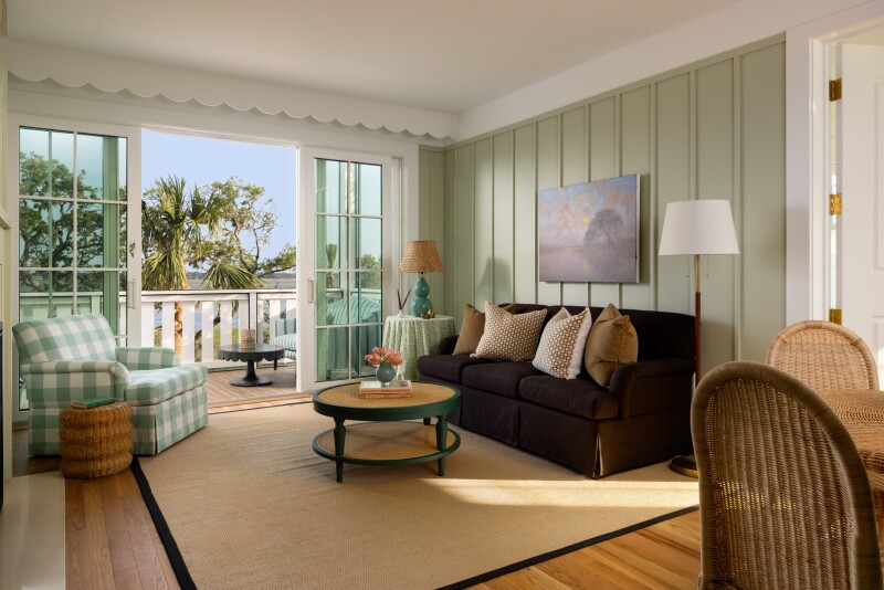 An upscale hotel room with a balcony looking out at palm trees