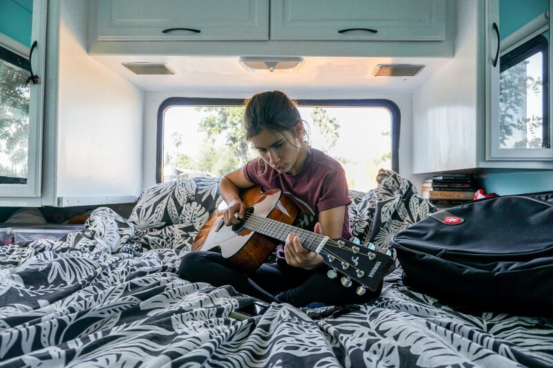 One of the Robledos' five children plays guitar in their fifth-wheel RV.
