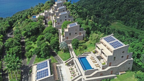 An aerial view of Coulibri Ridge, with solar panels, pool, and deck visible