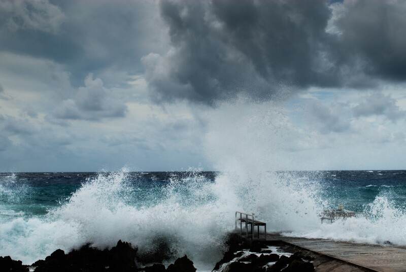 Hurricane Irma passing through the Grand Caymans: waves crashing onshore with dark cloudy sky